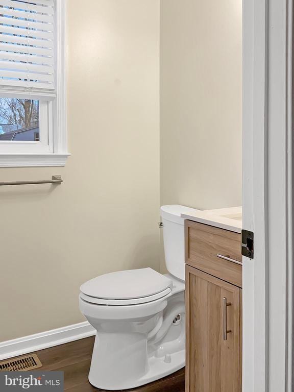 bathroom with vanity, toilet, and wood-type flooring