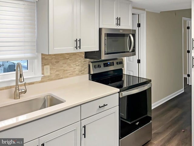 kitchen featuring stainless steel appliances, tasteful backsplash, sink, and white cabinets