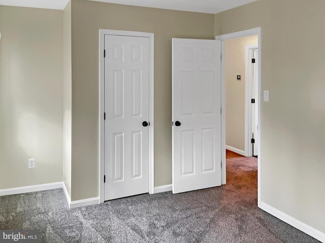 unfurnished bedroom with dark carpet