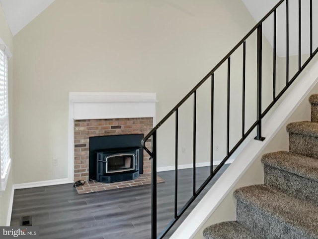 staircase with hardwood / wood-style flooring and high vaulted ceiling