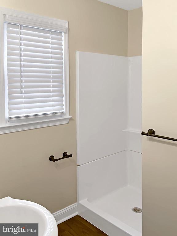 bathroom featuring a shower and hardwood / wood-style floors