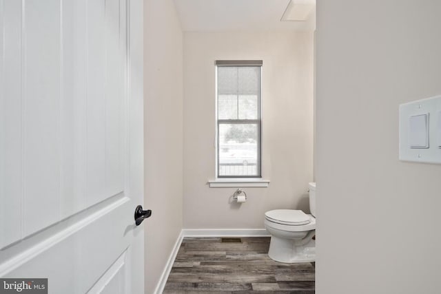 bathroom with baseboards, toilet, and wood finished floors