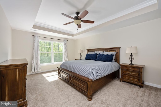bedroom featuring crown molding, baseboards, light colored carpet, and a raised ceiling