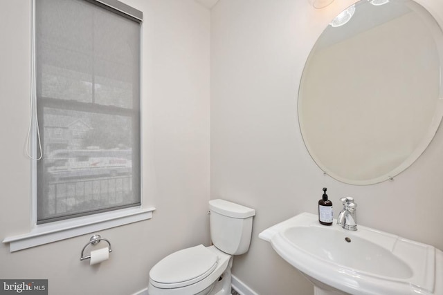 bathroom with a sink, baseboards, and toilet