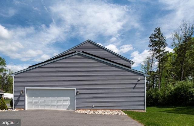 view of side of home featuring driveway and a garage