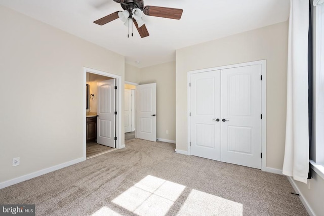 unfurnished bedroom with carpet flooring, baseboards, ensuite bath, and a closet