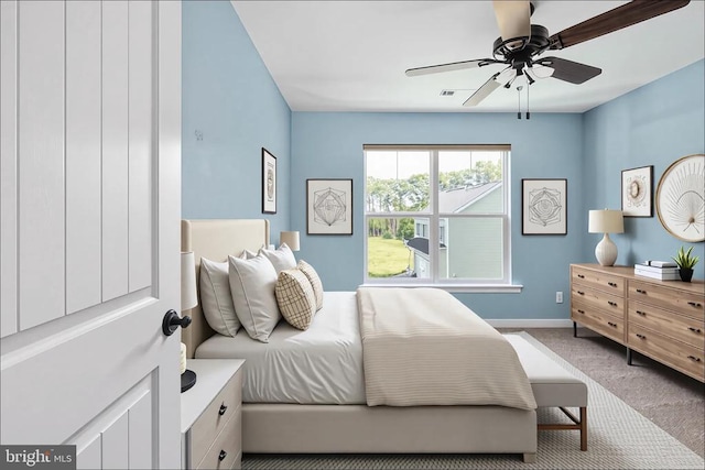 carpeted bedroom with visible vents, a ceiling fan, and baseboards