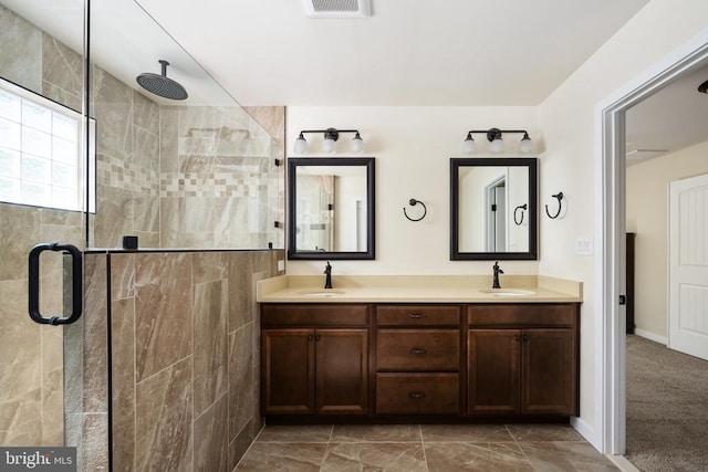 full bath featuring a sink, double vanity, a shower stall, and marble finish floor