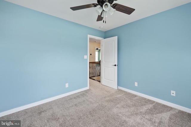 empty room with baseboards, carpet, and a ceiling fan