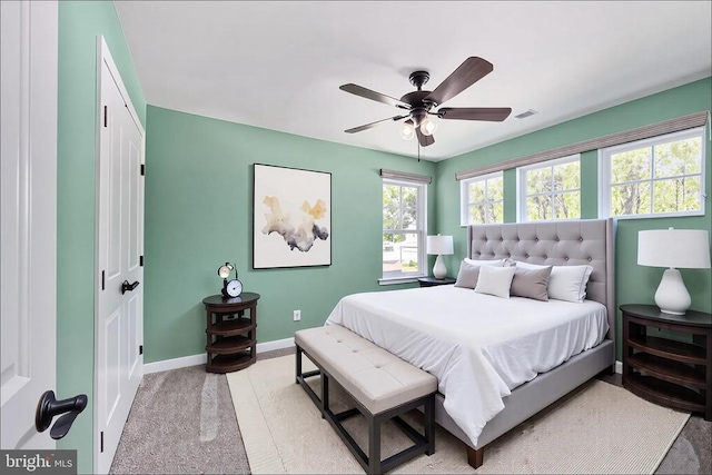 bedroom with a ceiling fan, baseboards, light colored carpet, and visible vents
