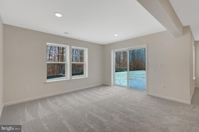 carpeted spare room featuring recessed lighting, visible vents, and baseboards