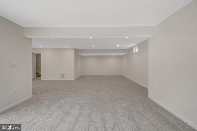 finished below grade area with recessed lighting, light carpet, baseboards, and stairs