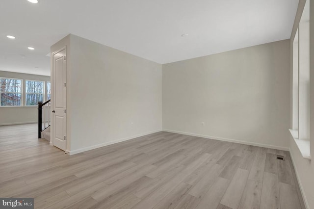 spare room featuring baseboards, recessed lighting, visible vents, and light wood-style floors