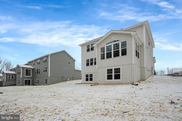 view of snow covered rear of property