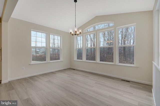 unfurnished dining area featuring a chandelier, light wood-style flooring, visible vents, baseboards, and vaulted ceiling