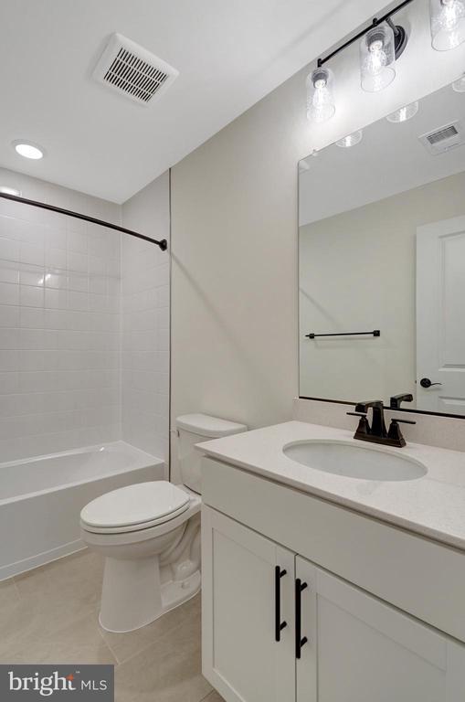 full bath featuring toilet, vanity, visible vents, and bathing tub / shower combination