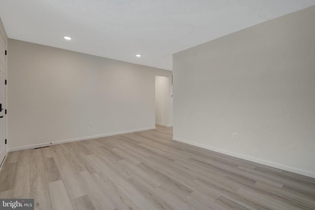 unfurnished room featuring light wood-type flooring, baseboards, and recessed lighting