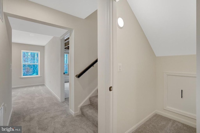 stairs featuring carpet, vaulted ceiling, and baseboards