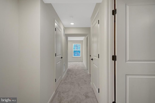 hallway with light carpet and baseboards