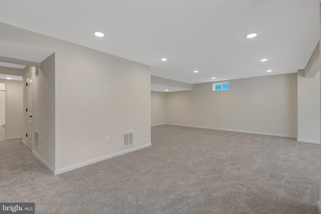 basement featuring baseboards, visible vents, and recessed lighting