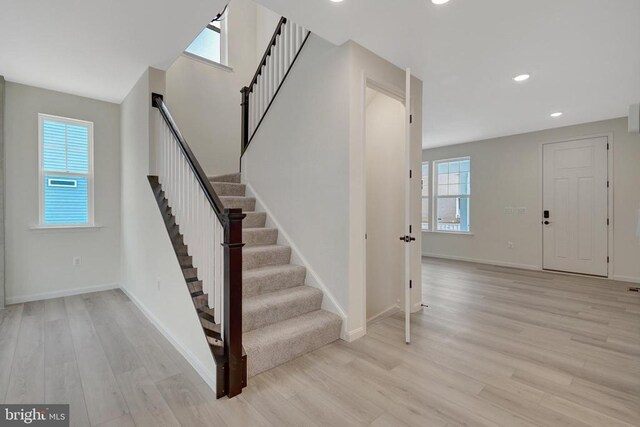 staircase featuring recessed lighting, wood finished floors, and baseboards