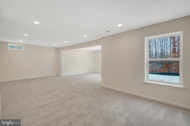 below grade area featuring baseboards, recessed lighting, visible vents, and light colored carpet