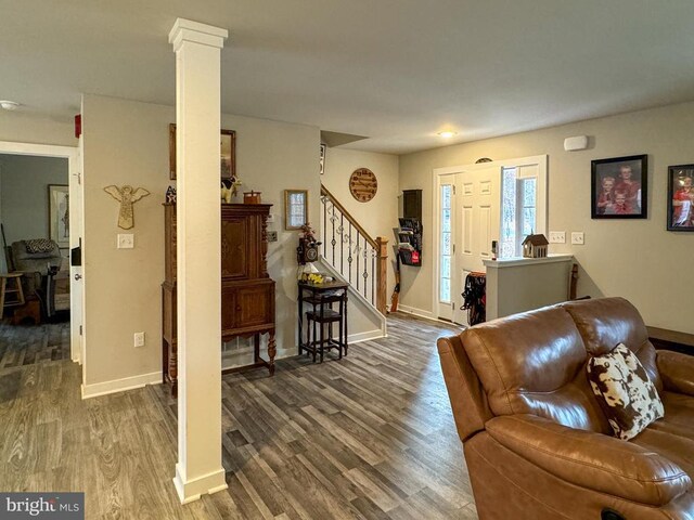 living room featuring dark hardwood / wood-style flooring and decorative columns