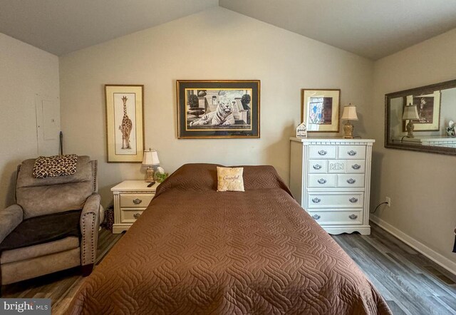 bedroom with dark wood-type flooring and vaulted ceiling