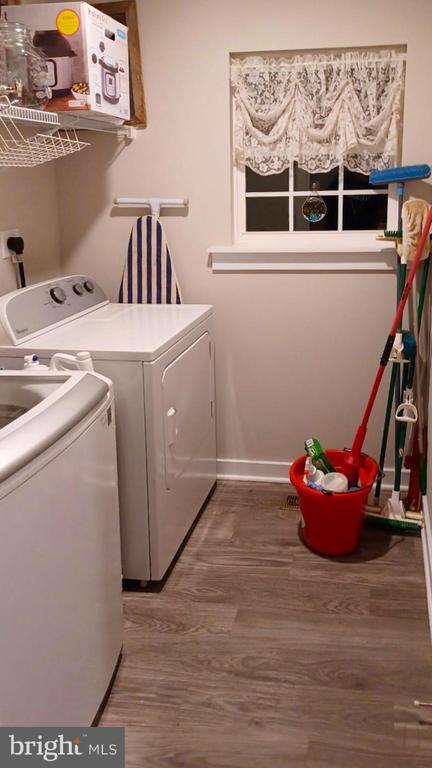 laundry room featuring hardwood / wood-style flooring and separate washer and dryer