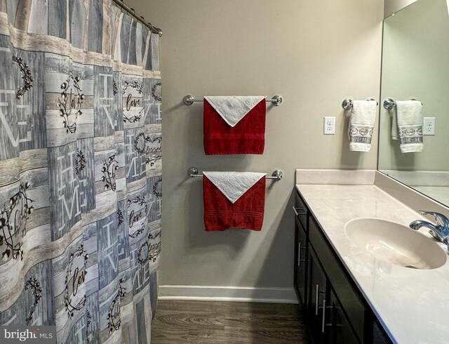 bathroom featuring hardwood / wood-style flooring, vanity, and walk in shower