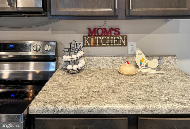 interior details with electric stove and dark brown cabinets