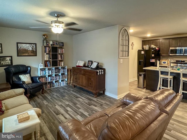 living room featuring light hardwood / wood-style floors and ceiling fan