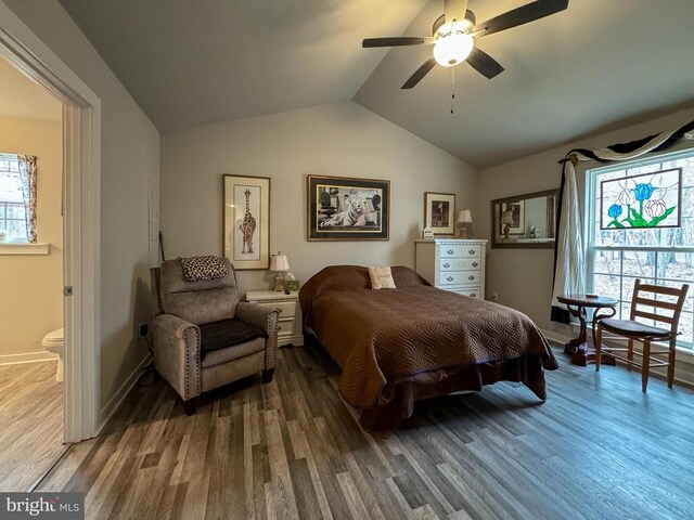 bedroom featuring ceiling fan, ensuite bathroom, vaulted ceiling, and hardwood / wood-style floors