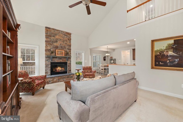 living room with high vaulted ceiling, baseboards, a stone fireplace, and light colored carpet