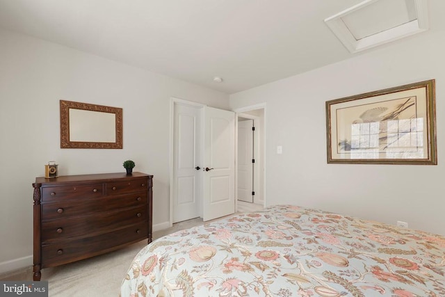 bedroom with attic access, light carpet, and baseboards