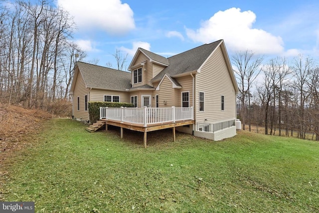 back of property featuring a shingled roof, a yard, and a wooden deck