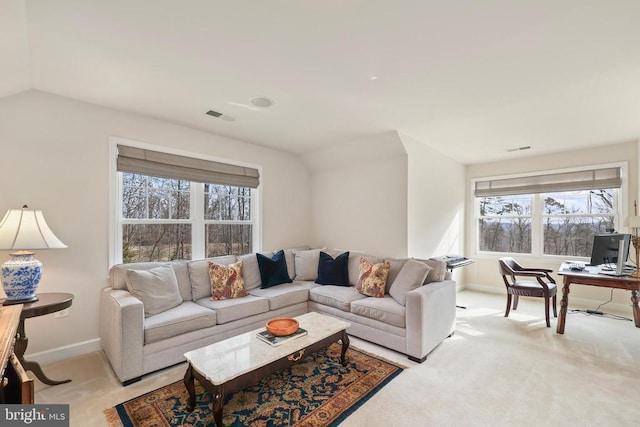 living area with light carpet, visible vents, and baseboards