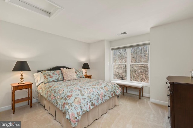 bedroom with attic access, light carpet, visible vents, and baseboards