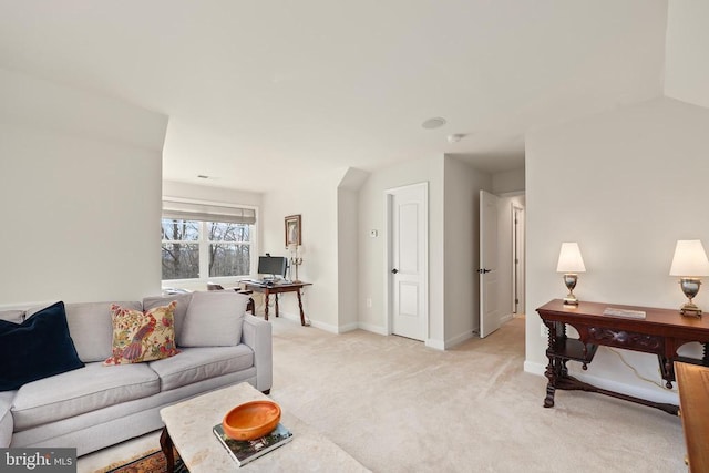 living area with baseboards and light colored carpet