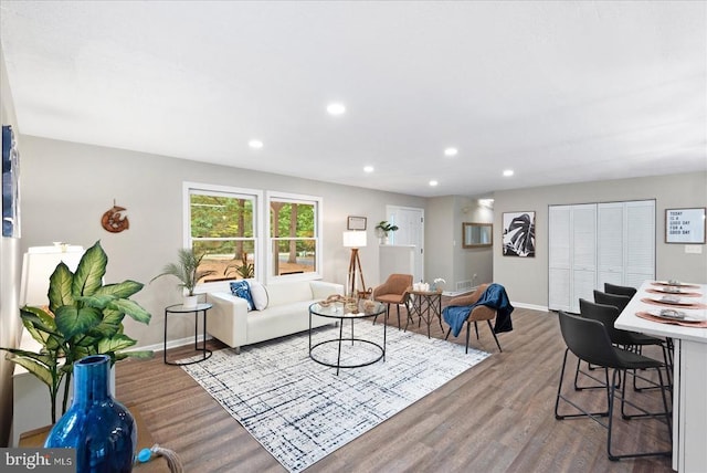 living room with recessed lighting, baseboards, and wood finished floors