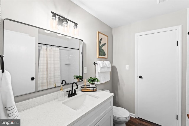 bathroom featuring toilet, a shower with shower curtain, and vanity