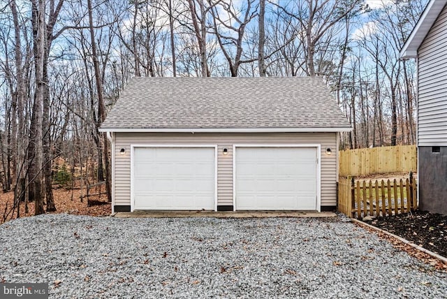 detached garage featuring fence