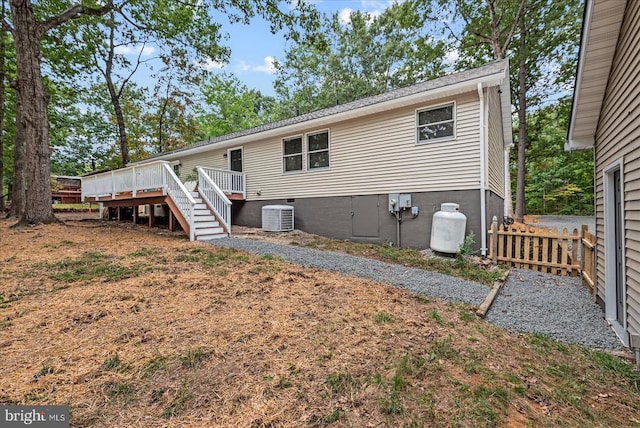 rear view of house with stairway, central AC unit, fence, and a wooden deck