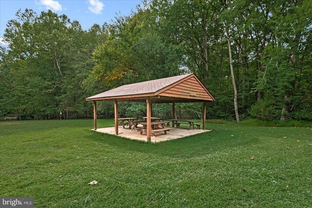 view of home's community with a gazebo, a lawn, a wooded view, and a patio