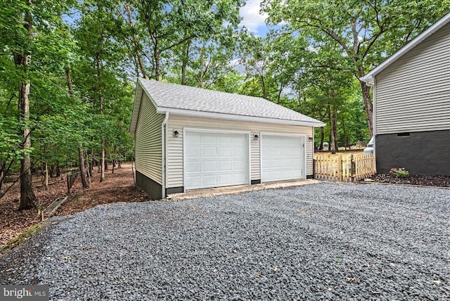 detached garage featuring fence