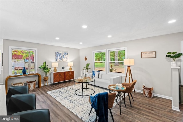 living room featuring recessed lighting, dark wood finished floors, a textured ceiling, and baseboards