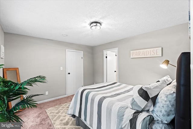 bedroom featuring baseboards, carpet floors, and a textured ceiling