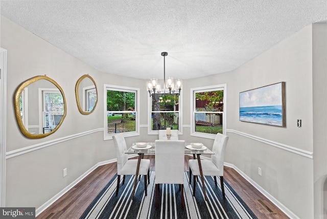 dining area with a notable chandelier, baseboards, and dark wood-type flooring