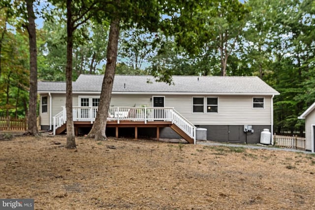 rear view of property featuring fence, stairway, a wooden deck, and central AC unit