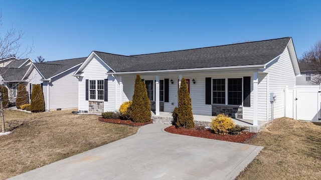 ranch-style house featuring roof with shingles, a front yard, and a gate